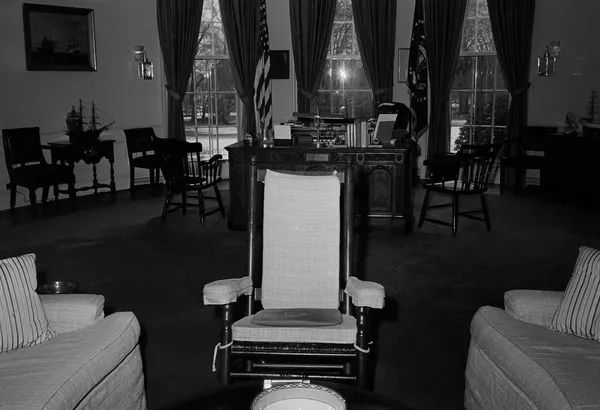 El escritorio Resolute, el más frecuentemente seleccionado por los presidentes, fue un regalo de la reina Victoria en 1880. El mueble se fabricó a partir de la madera de un buque británico llamado el HMS Resolute. Durante el mandato de John Kennedy, la primera dama, Jacqueline, se encargó de restaurar el escritorio.En la foto: la mecedora de Kennedy en la Oficina Oval de la Casa Blanca, en primer plano; al fondo, el escritorio Resolute (1962). El escritorio Resolute, el más frecuentemente seleccionado por los presidentes, fue un regalo de la reina Victoria en 1880. El mueble se fabricó a partir de la madera de un buque británico llamado el HMS Resolute. Durante el mandato de John Kennedy, la primera dama, Jacqueline, se encargó de restaurar el escritorio.En la foto: la mecedora de Kennedy en la Oficina Oval de la Casa Blanca, en primer plano; al fondo, el escritorio Resolute (1962). - Sputnik Mundo