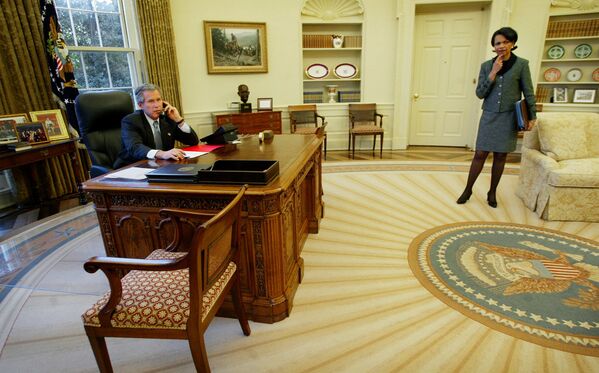 George W. Bush, entre otras cosas, agregó un busto del primer ministro británico Winston Churchill a la decoración del Despacho Oval. La escultura volvió a la oficina presidencial años más tarde, durante el mandato de Trump.En la foto: el presidente Bush habla por teléfono desde el Despacho Oval. A la derecha, Condoleezza Rice, secretaria de Estado de los Estados Unidos (2003). - Sputnik Mundo