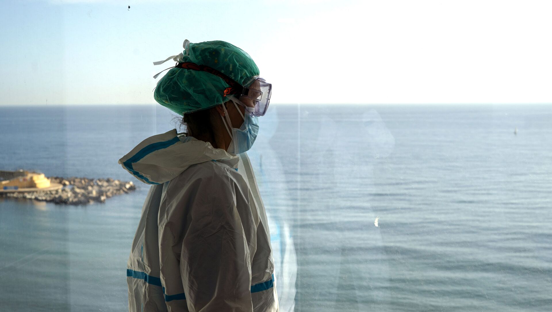 La enfermera Marta Fernández mira el mar desde una ventana durante un breve descanso en la sala COVID-19 del hospital del Mar en Barcelona - Sputnik Mundo, 1920, 02.02.2021