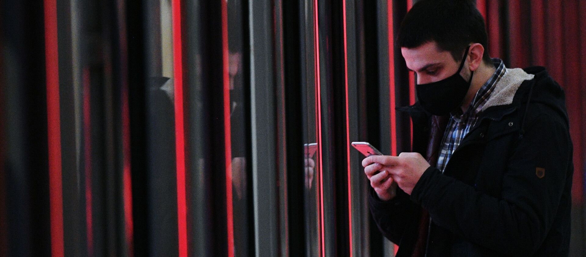 Una persona en mascarilla con un teléfono móvil (referencial) - Sputnik Mundo, 1920, 02.02.2021