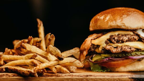 Una hamburguesa con papas fritas - Sputnik Mundo