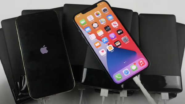 un iPhone 12 Pro Max con un cargador MagSafe y el otro con 10 'powerbanks'  - Sputnik Mundo