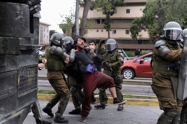 Los vídeos captados por las cámaras de seguridad revelan que el carabinero realizó varios disparos de advertencia en el suelo. No obstante, el malabarista —que sujetaba en sus manos objetos parecidos a machetes— persistió en abalanzarse contra los uniformados que, a su vez, no tuvieron otra opción más que disparar contra el artista callejero. En la foto: la Policía detiene a un manifestante. - Sputnik Mundo