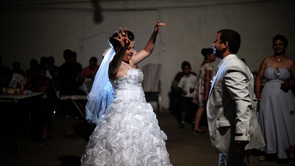 Una pareja romaní de recién casados ​​baila durante su fiesta de bodas en el pueblo de Dolni Tsibar en el río Danubio. - Sputnik Mundo