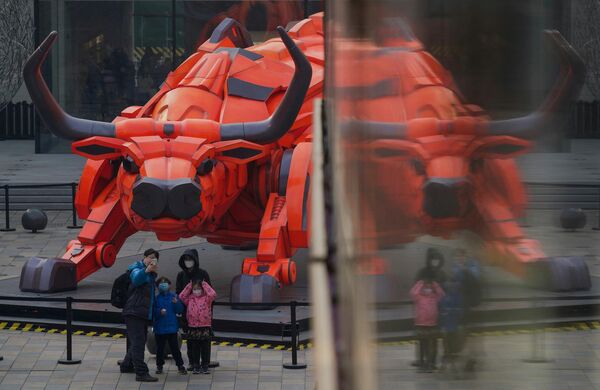 Durante el Año Nuevo lunar —más conocido como la Fiesta de la Primavera en China— Pekín ha prohibido los fuegos artificiales y los petardos. En esta foto: una familia frente a una escultura de un toro en un centro comercial de Pekín en vísperas del Año Nuevo lunar. - Sputnik Mundo