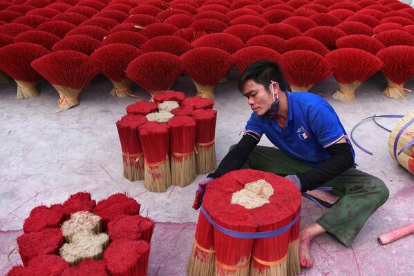 Un hombre empaca palitos aromatizantes cerca de Hanói, Vietnam. - Sputnik Mundo