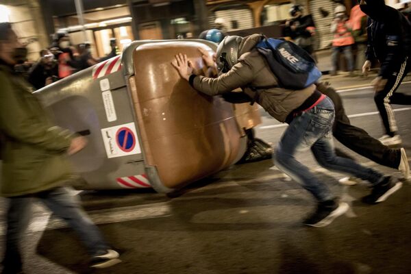 Docenas de manifestantes salieron a las calles de Barcelona para demostrar su apoyo al rapero Pablo Hasél, luego de que fuera detenido para cumplir nueve meses de prisión por insultar a la monarquía y enaltecer el terrorismo. Pablo Hasél también recibió una pena de dos años y medio tras su detención. - Sputnik Mundo