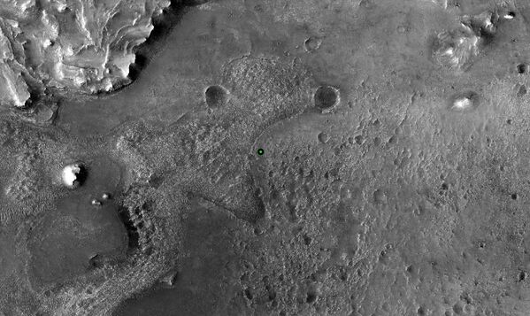 Un punto verde marca el lugar donde el Perseverance aterrizó en el cráter Jezero en Marte el 18 de febrero de 2021. La imagen fue tomada por la cámara HiRISE a bordo del orbitador de reconocimiento Mars Reconnaissance Orbiter de la NASA. - Sputnik Mundo