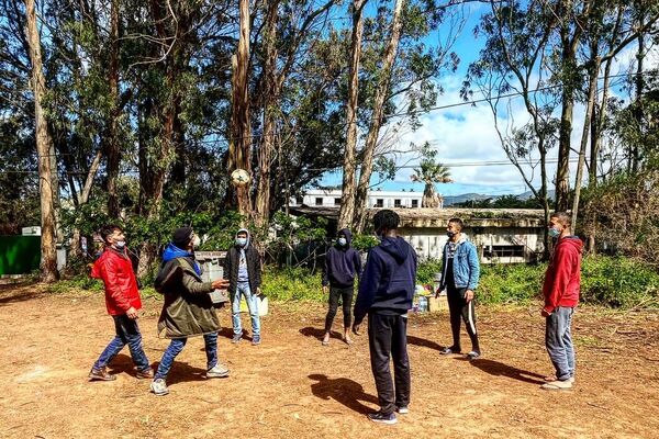 Varios inmigrantes juegan al fútbol frente al campamento Las Raíces, en Tenerife - Sputnik Mundo