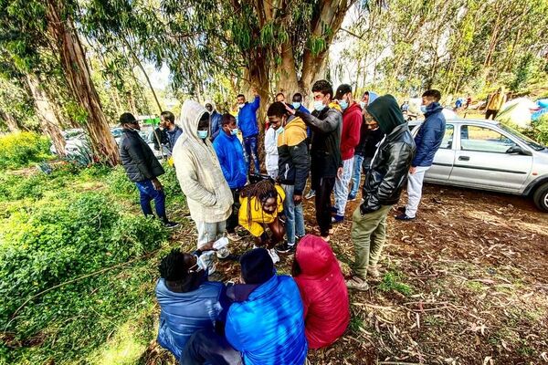 Varios inmigrantes esperan frente al campamento de Las Raíces, en Tenerife - Sputnik Mundo