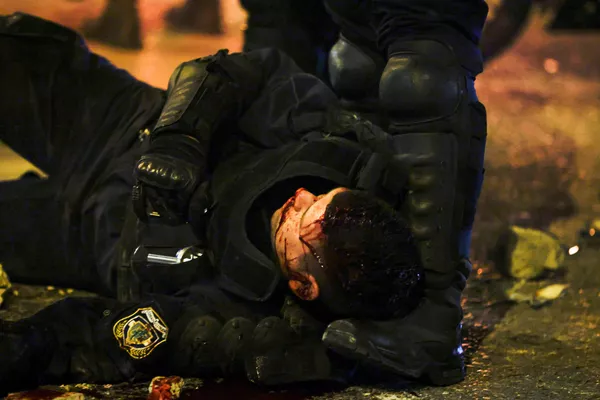 La multitud enfurecida atacó a uno de los policías, lo tiró de su moto y lo golpeó. El agente fue trasladado al hospital con una herida en la cabeza. Varios uniformados también resultaron heridos por la lluvia de piedras y petardos. En la foto: un agente de la Policía herido durante los disturbios en Atenas.   - Sputnik Mundo