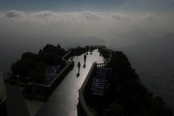 La estatua del Cristo Redentor es una de las principales atracciones turísticas de Brasil. Antes de la pandemia de COVID-19, recibía a casi dos millones de turistas anualmente.En la foto: personas visitan el Cristo Redentor, durante su restauración - Sputnik Mundo