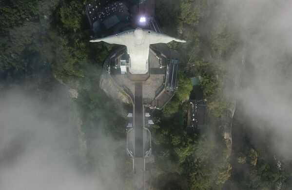 Para garantizar un resultado final perfecto, el equipo ha realizado registros fotogramétricos aéreos y terrestres, así como ha tomado instantáneas del monumento con drones fotográficos de alta resolución.En la foto: la estatua del Cristo Redentor, vista desde arriba, durante su restauración - Sputnik Mundo