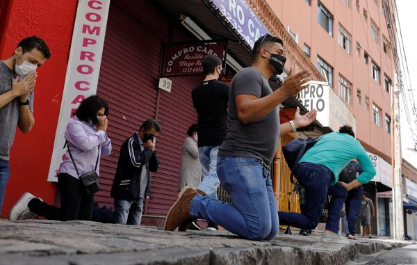 Los fieles rezan durante una misa del Domingo de Pascua fuera del Santuario de Nuestra Señora de Guadalupe, en medio del brote de coronavirus en Curitiba (Brasil). - Sputnik Mundo