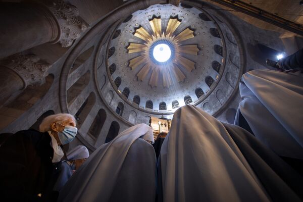 Una mujer que lleva una mascarilla asiste a una misa del Domingo de Pascua encabezada por el patriarca latino de Jerusalén, Pierbattista Pizzaballa, en la Iglesia del Santo Sepulcro, donde muchos cristianos creen que Jesús fue crucificado, enterrado y resucitado en la Ciudad vieja de Jerusalén. - Sputnik Mundo