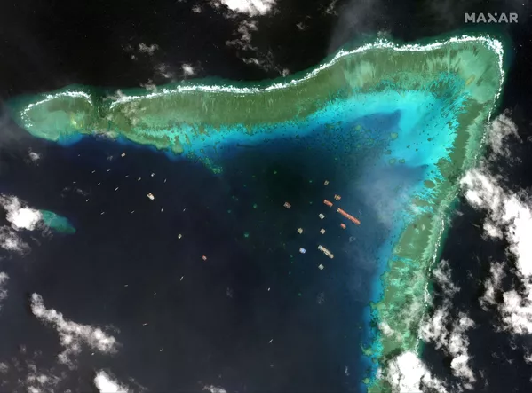 Las embarcaciones pesqueras en el arrecife Whitsun, llamado por Manila arrecife de Julián Felipe, en una imagen satelital de la compañía Maxar tomada el 23 de marzo de 2021. - Sputnik Mundo