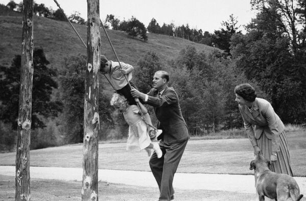 El duque de Edimburgo balancea a sus hijos, el príncipe Carlos y la princesa Ana, en un columpio en el castillo de Balmoral (agosto de 1955). - Sputnik Mundo