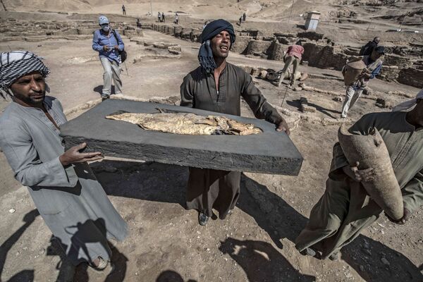 Unos obreros sostienen un pez fosilizado descubierto en el yacimiento arqueológico de una ciudad de 3.000 años de antigüedad denominada Ascenso de Atón y fundada por el faraón Amenhotep III. Los arqueólogos afirman que esta ciudad antigua, que se remonta a la época dorada de los faraones, es &quot;la más grande&quot; jamás encontrada en Egipto. El famoso egiptólogo Zahi Hawass anunció el descubrimiento de esta &#x27;ciudad dorada perdida&#x27;, que también alberga el legendario Valle de los Reyes. - Sputnik Mundo