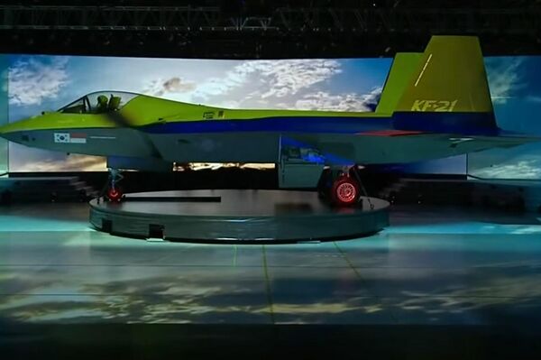 Caza KF-21 con proyecciones de distintas banderas sobre su fuselaje durante su presentación oficial.  - Sputnik Mundo