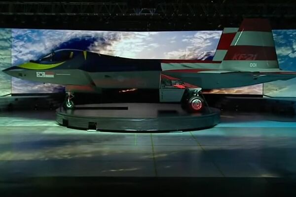 Caza KF-21 con proyecciones de distintas banderas sobre su fuselaje durante su presentación oficial.  - Sputnik Mundo