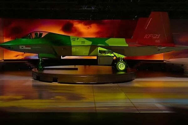 Caza KF-21 con proyecciones de distintas banderas sobre su fuselaje durante su presentación oficial.  - Sputnik Mundo