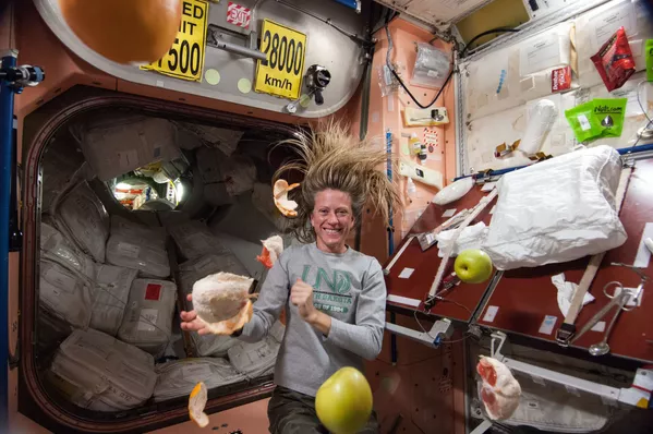 La astronauta de la NASA Karen Nyberg, ingeniera de vuelo de la Expedición 36, cerca de la fruta fresca que flota libremente en el nodo Unity de la Estación Espacial Internacional. La astronauta de la NASA Karen Nyberg, ingeniera de vuelo de la Expedición 36, cerca de la fruta fresca que flota libremente en el nodo Unity de la Estación Espacial Internacional. - Sputnik Mundo