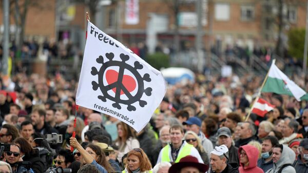 Unos manifestantes asisten a una protesta en Stuttgart (Alemania) contra las restricciones impuestas por el Gobierno en el marco de la pandemia de COVID-19 el 3 de abril - Sputnik Mundo