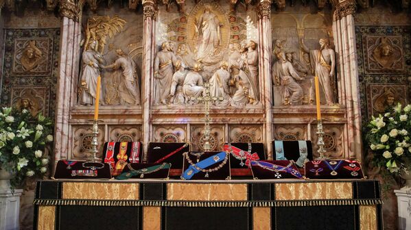 La familia real británica estará de luto durante dos semanas después de la muerte del príncipe. El luto será respetado también por su personal, así como por las unidades militares especiales que realizan tareas ceremoniales.En la foto: las insignias del duque de Edimburgo en el altar de la capilla de San Jorge. - Sputnik Mundo