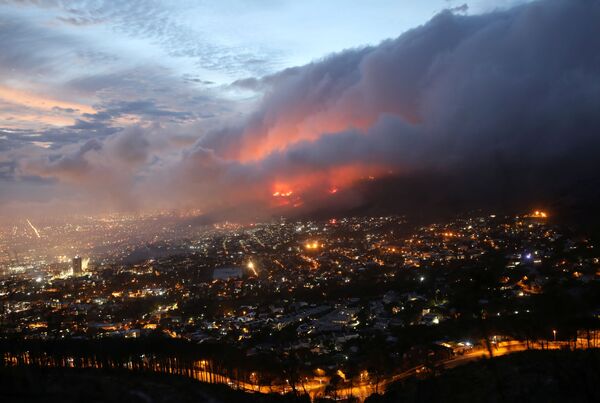 El incendio destruyó una parte del monumento al famoso político sudafricano Cecil Rhodes, que se sitúa en Devil&#x27;s Peak (Pico del Diablo, en inglés). El fuego se propagó rápidamente por las laderas boscosas, se extendió a los edificios de la Universidad de Ciudad del Cabo y provocó la evacuación de cientos de estudiantes.En la foto: vista aérea del incendio en las laderas de la Montaña de la Mesa, en Ciudad del Cabo. - Sputnik Mundo