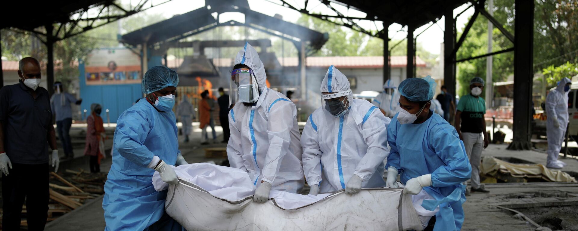 Varias personas con trajes de bioseguridad evacúan a las personas que fallecieron por coronavirus en la India Varias personas con trajes de bioseguridad evacúan a las personas que fallecieron por coronavirus en la India - Sputnik Mundo, 1920, 28.04.2021