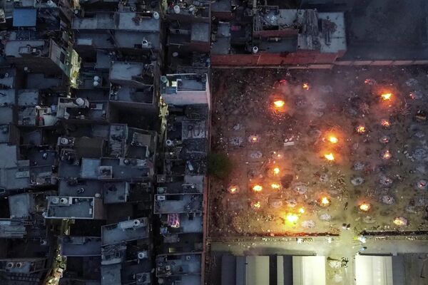 Una vista aérea de las piras funerarias cerca de un barrio en Nueva Delhi, India. - Sputnik Mundo