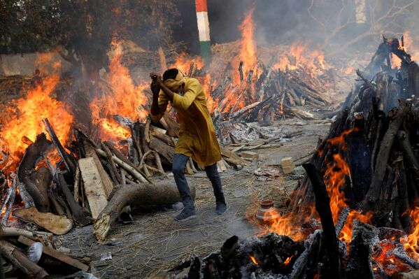 Según los datos oficiales, el número total de personas infectadas en India ha superado los 17,6 millones. Muchos hospitales se están quedando sin espacio y sin oxígeno médico, lo que provoca la muerte de los pacientes.En la foto: una cremación masiva de los muertos del COVID-19 en Nueva Delhi. - Sputnik Mundo