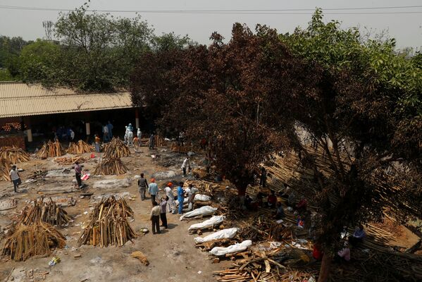 Las tradiciones indias prevén la cremación, pero no de esta forma. Normalmente, los muertos son llevados a estructuras especiales en las orillas de los ríos sagrados y se utiliza la leña de ciertos árboles.En la foto: preparación de las hogueras para una cremación masiva de los muertos del COVID-19 en Nueva Delhi. - Sputnik Mundo