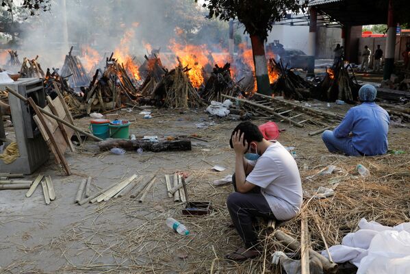 Una nueva cepa de coronavirus, la B1617, circula ahora por la India y muchos expertos creen que es más contagiosa y mortal que las anteriores.En la foto: los familiares de los fallecidos por COVID-19 durante una cremación masiva en Nueva Delhi. - Sputnik Mundo