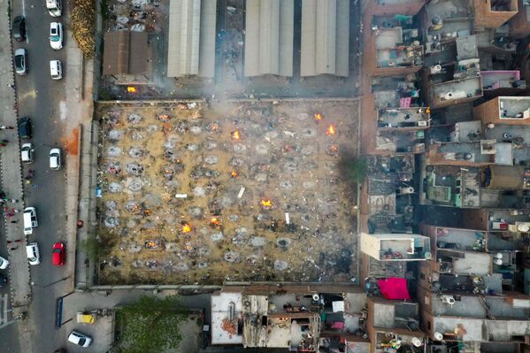 En medio de la grave situación generada por el COVID-19, Rusia suministrará la vacuna Sputnik V a la India; el primer lote llegará el 1 de mayo.En la foto: unas hogueras funerarias arden durante una cremación masiva en Nueva Delhi. - Sputnik Mundo
