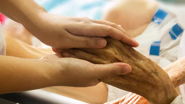 Una persona sosteniendo la mano de un paciente - Sputnik Mundo