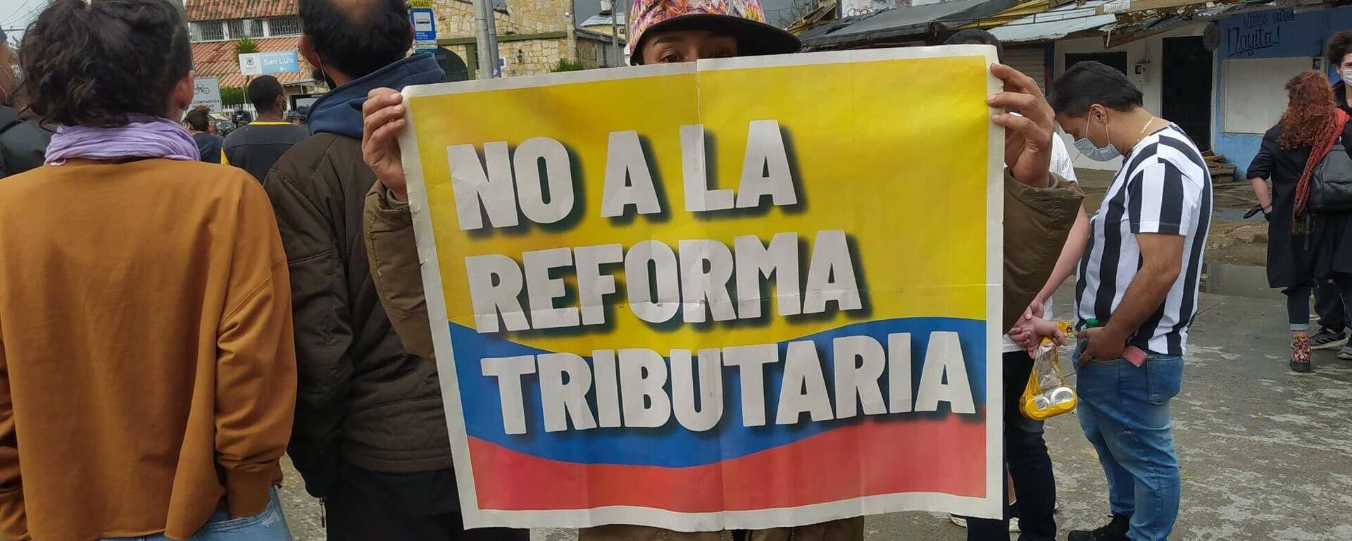 Una manifestante con un cartel contra la reforma propuesta por el Gobierno de Iván Duque - Sputnik Mundo, 1920, 29.04.2021