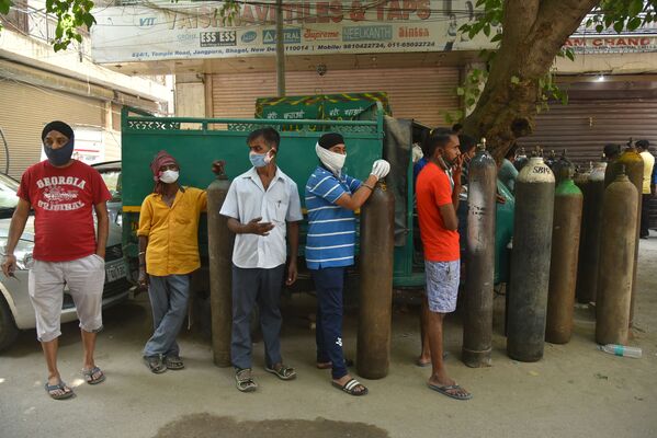 Ahora se permiten usar tanques de oxígeno, que se han convertido en el artículo más escaso, solo con fines médicos. En la foto: una cola cerca de la estación de recarga de cilindros de oxígeno medicinal en Delhi. - Sputnik Mundo