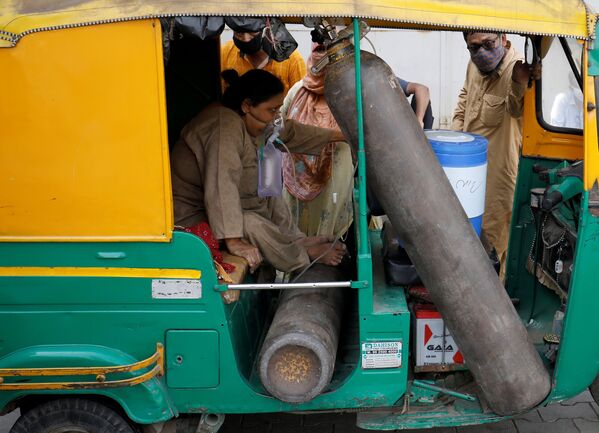 Una mujer con una máscara de oxígeno espera su turno para ser hospitalizada en la ciudad de Ahmedabad.  - Sputnik Mundo