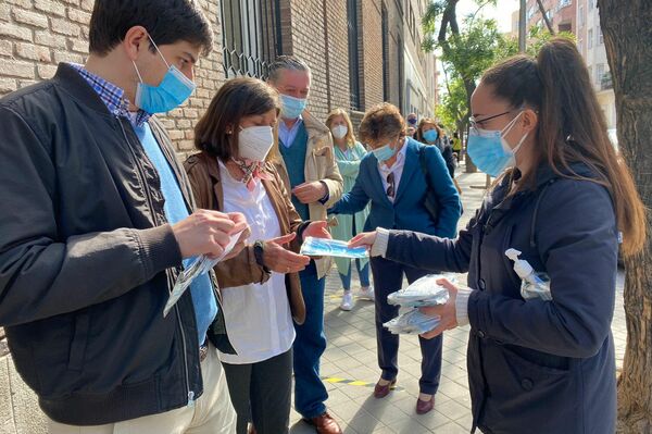 Reparto de mascarillas en la cola para votar en las elecciones a la Comunidad de Madrid. - Sputnik Mundo