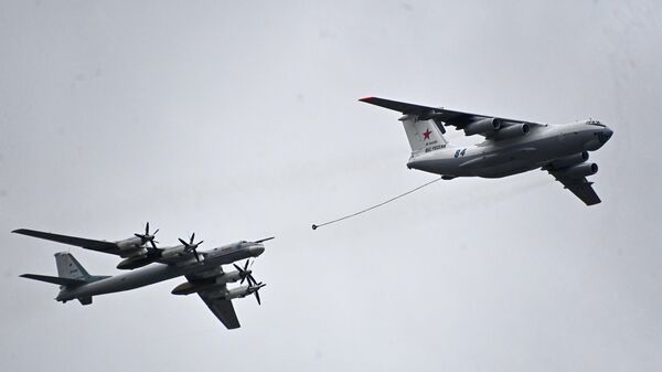 El avión cisterna Il-78 y el bombardero portamisiles estratégico Tu-95 muestran un reabastecimiento aéreo sobre la Plaza Roja.  - Sputnik Mundo