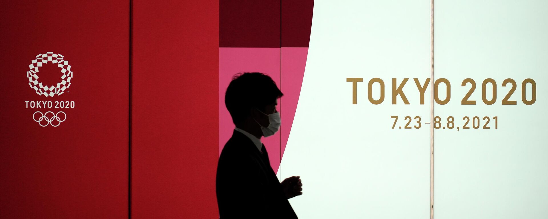 Un hombre camina junto a una pared de los Juegos Olímpicos de Tokio 2020 - Sputnik Mundo, 1920, 14.05.2021