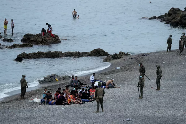 El número de personas que llegaron desde Marruecos buscando entrar de forma ilegal a España se disparó a lo largo del día. En la foto: unos oficiales españoles rodean a ciudadanos marroquíes en la frontera de los dos países. El número de personas que llegaron desde Marruecos buscando entrar de forma ilegal a España se disparó a lo largo del día. En la foto: unos oficiales españoles rodean a ciudadanos marroquíes en la frontera de los dos países. - Sputnik Mundo