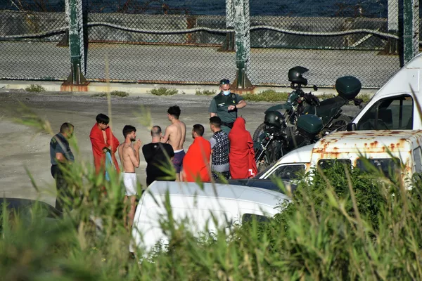 La mayor parte de los migrantes son hombres jóvenes, pero también hay varias familias.En la foto: migrantes que llegaron desde Marruecos y oficiales españoles en la playa del Tarajal. La mayor parte de los migrantes son hombres jóvenes, pero también hay varias familias.En la foto: migrantes que llegaron desde Marruecos y oficiales españoles en la playa del Tarajal. - Sputnik Mundo