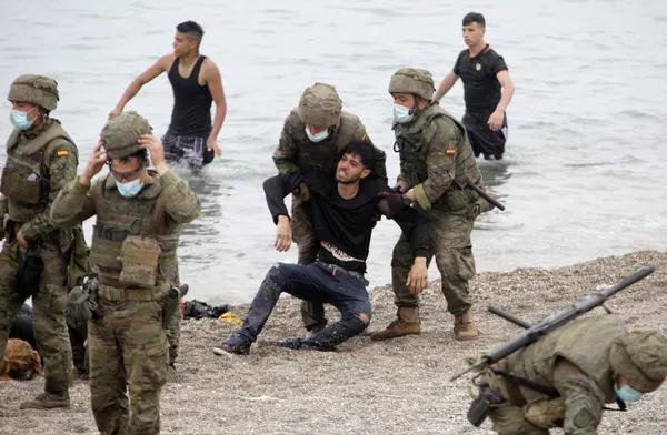 Un total de 200 soldados, más 200 policías adicionales, proporcionarán apoyo a la fuerza fronteriza usual de 1.100 efectivos de Ceuta, informó el Interior español.En la foto: unos militares españoles sostienen a un hombre que llegó a nado en Ceuta. Un total de 200 soldados, más 200 policías adicionales, proporcionarán apoyo a la fuerza fronteriza usual de 1.100 efectivos de Ceuta, informó el Interior español.En la foto: unos militares españoles sostienen a un hombre que llegó a nado en Ceuta. - Sputnik Mundo