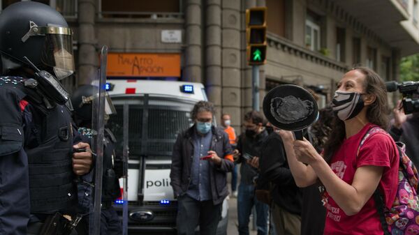 Una mujer, perteneciente a activistas vinculados a sindicatos de la vivienda de Barcelona, golpea una sartén frente a los Mossos d'Esquadra - Sputnik Mundo