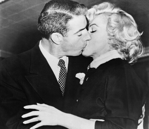  Monroe se casó por primera vez cuando solo tenía 16 años, pero el matrimonio terminó en divorcio. Pasó por el altar dos veces más: en 1954, con el beisbolista Joe DiMaggio y en 1956, con el escritor Arthur Miller, de quien se divorció en 1961. Monroe también mantuvo relaciones con los cantantes Yves Montaigne y Franc Sinatra y supuestamente con los políticos Robert y John F. Kennedy. Existe una teoría de conspiración que asegura que esta última relación derivó en la muerte de la actriz, pues no se suicidó, sino que fue asesinada por los servicios especiales de EEUU.  En la foto: Marilyn junto a su segundo esposo. - Sputnik Mundo