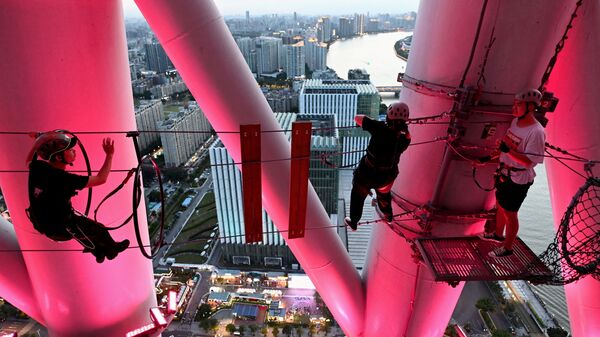 Посетители и их гид, пересекающие канат в парке приключений Canton Tower в Гуанчжоу - Sputnik Mundo