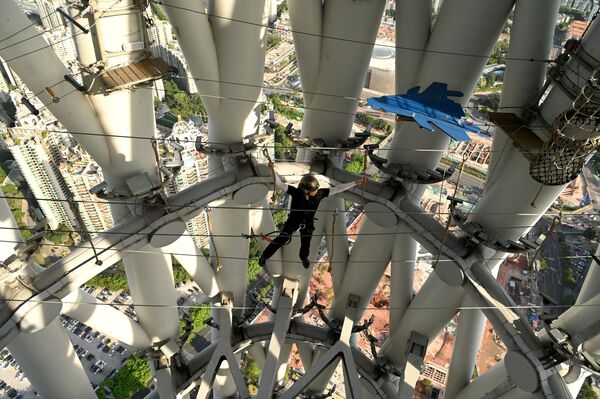 En esta torre puedes caminar sobre una cuerda con arnés, superar una carrera de obstáculos y subir hasta arriba. Y todo ello a una altura de casi 300 m sobre el suelo. En la foto: un guía camina sobre ella. - Sputnik Mundo