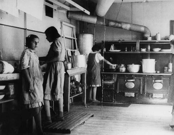 Se supone que mientras existieron las escuelas residenciales para menores indígenas murieron por lo menos 3.000 alumnos.En la foto: las niñas cocinan en la escuela residencial Bishop Horden, en 1940. - Sputnik Mundo